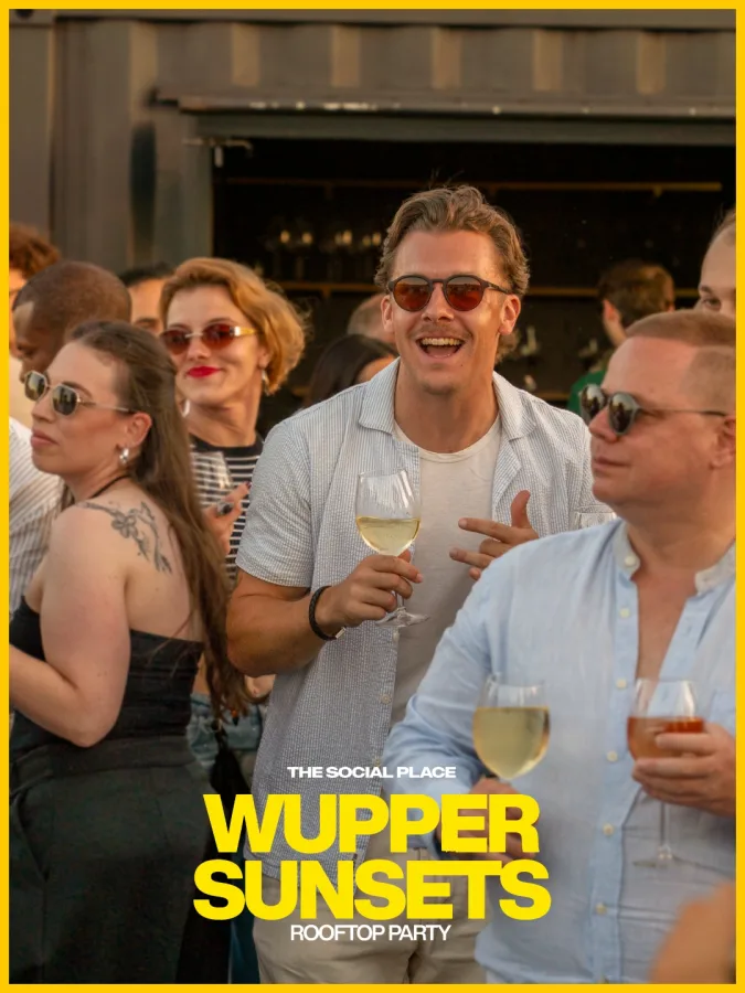 Gäste mit Weingläsern vor der Rooftop-Bar