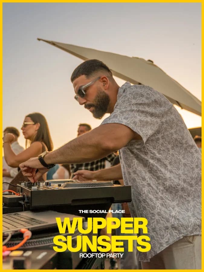 DJ am Plattenspieler auf der Dachterrasse zum Sonnenuntergang